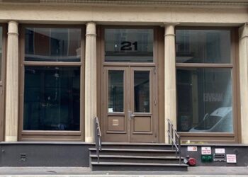 A building with a door and windows at 21 Mercer St. in Soho