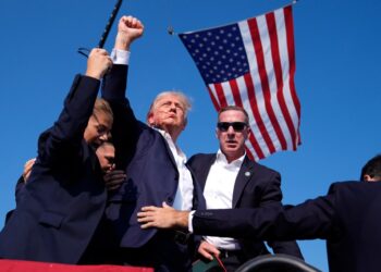 Former President Donald Trump surrounded by U.S. Secret Service agents at a campaign rally in Butler, Pennsylvania in 2024