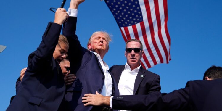 Former President Donald Trump surrounded by U.S. Secret Service agents at a campaign rally in Butler, Pennsylvania in 2024