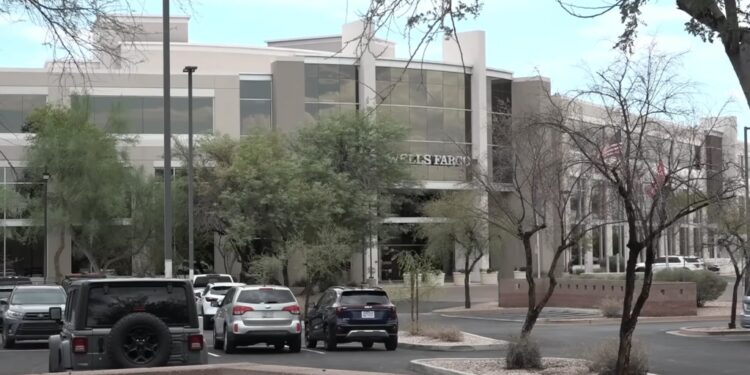 A Wells Fargo office building with parked cars in front, where an employee was found deceased in her cubicle.