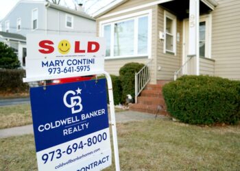 A house in Hawthorne, NJ with a 'Sold' and 'Under Contract' sign from Coldwell Banker Realty, representing a significant increase in real estate sales in December 2024.