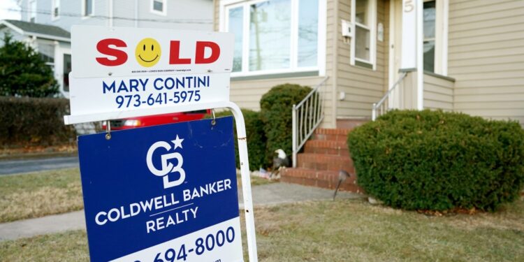 A house in Hawthorne, NJ with a 'Sold' and 'Under Contract' sign from Coldwell Banker Realty, representing a significant increase in real estate sales in December 2024.