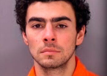 Luigi Mangione in a jumpsuit during a mugshot.