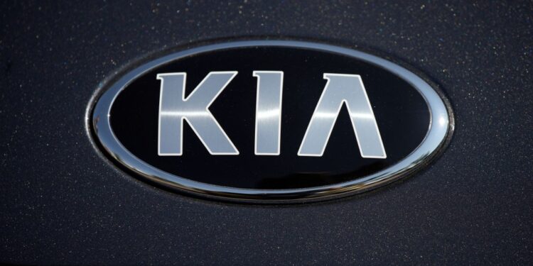 The company logo shines off the hood of a 2021 K5 sedan on display in the Kia exhibit at the Denver auto show Friday, Sept. 17, 2021