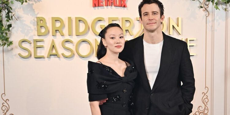 Yerin Ha and Luke Thompson attend the "Bridgerton: Season Of Love" fan event at Raffles London at The OWO on February 14, 2025 in London, England in black outfits