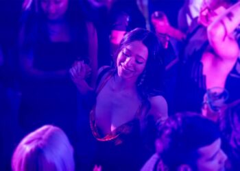 Mikey Madison and Jan Švankmajer in a crowd with a woman dancing