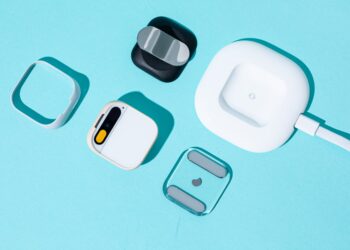 A photo of the Humane AI Pin with several accessories.