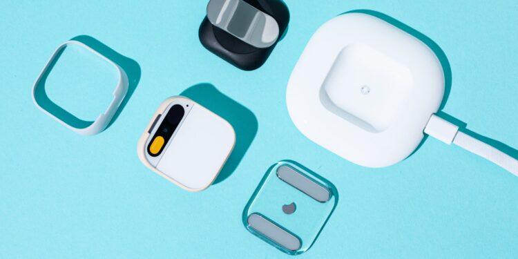 A photo of the Humane AI Pin with several accessories.