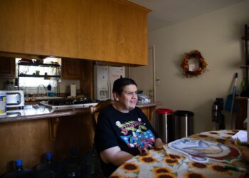 A man sits at a kitchen table.