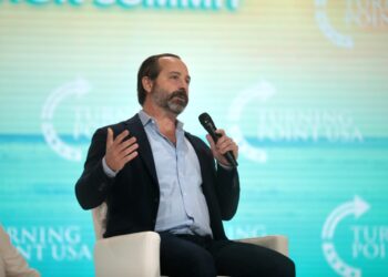 Chris Buskirk holding a microphone and speaking with attendees at the 2021 Student Action Summit at Tampa Convention Center