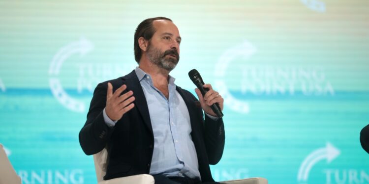 Chris Buskirk holding a microphone and speaking with attendees at the 2021 Student Action Summit at Tampa Convention Center