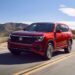 Volkswagen 2025 Atlas in red driving down road.