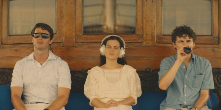 Shawn Mendes, Patrick Schwarzenegger, and Laura Närhi sitting on a bench smoking in a setting titled 'White Lotus'