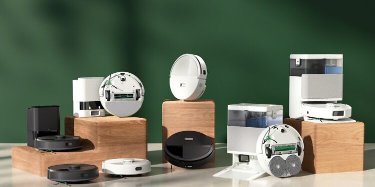 A family of robot vacuums posed on a green background.