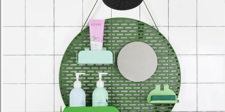 A shower organizer hanging from a shower nozzle with little shelves holding bottles.