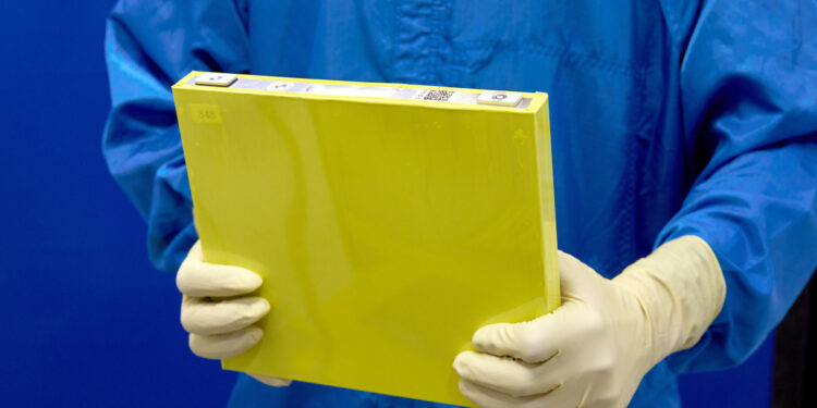An employee holds a full-size prototype LMR battery cell at the General Motors Wallace Battery Cell Innovation Center.