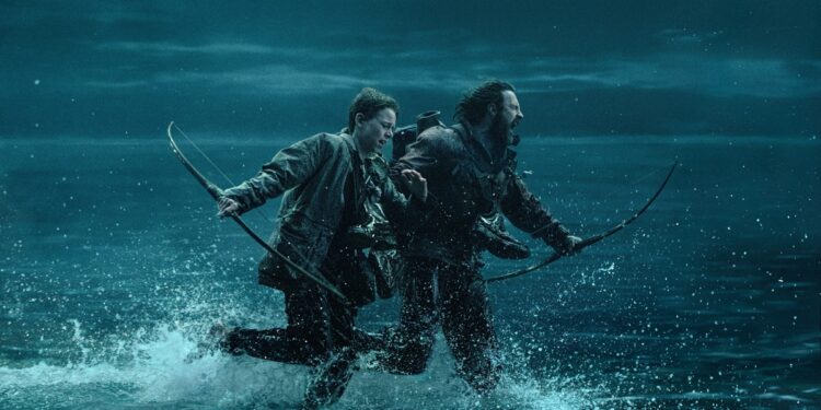 A man and a boy holding longbows while running on a path that’s being flooded by the rising tide.