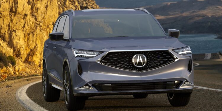 Acura MDX driving on a road.