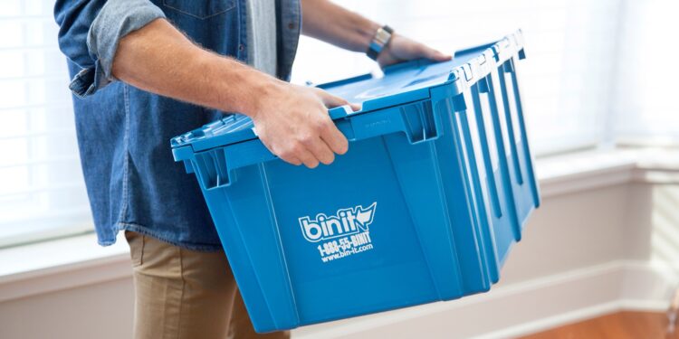 Person holding a plastic moving bin.