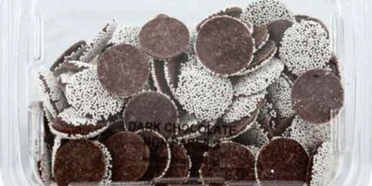 Dark chocolate nonpareils in a clear plastic container.