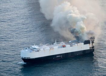 Cargo ship on fire at sea.