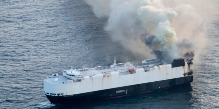 Cargo ship on fire at sea.