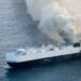 Cargo ship on fire at sea.