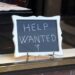 Help wanted sign in restaurant window.
