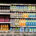 Grocery store shelf stocked with various brands of coconut water and other beverages.