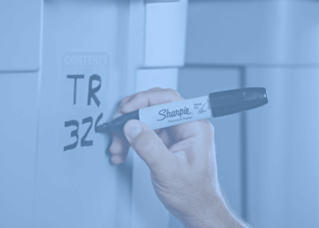 Hand using a sharpie pen to write on a bin.