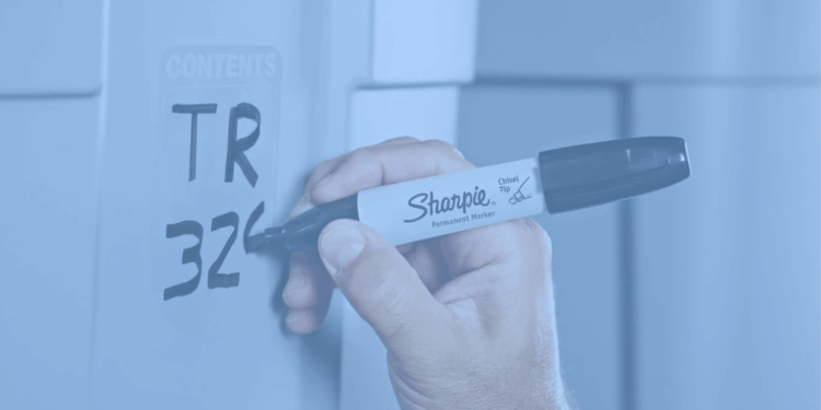 Hand using a sharpie pen to write on a bin.