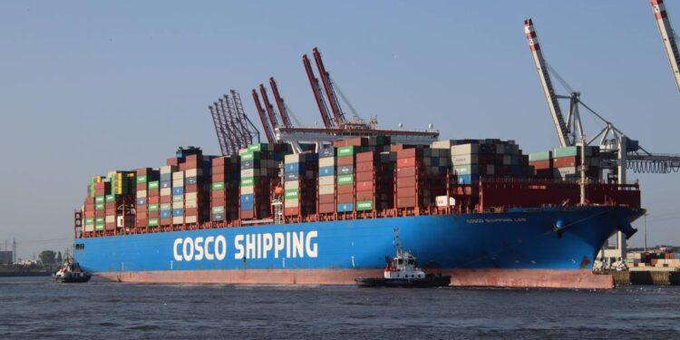 Large container ship Cosco Shipping Leo being towed into port.
