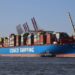 Large container ship Cosco Shipping Leo being towed into port.