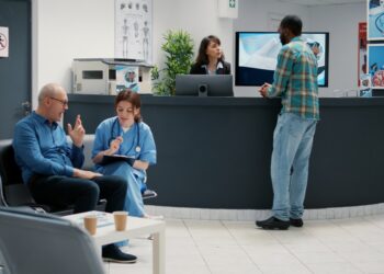 Diverse patients waiting in a hospital lobby.