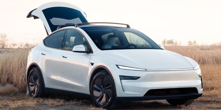 A new Tesla Model Y in white with the trunk raised.