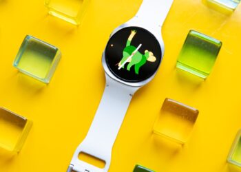 Wide view of the Samsung Galaxy Watch 8 on a yellow table with colorful green, yellow, orange, and pink acrylic blocks around it.