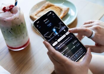 Person looking at their glucose levels in the Oura app with a strawberry matcha latte and a pastry in the background.