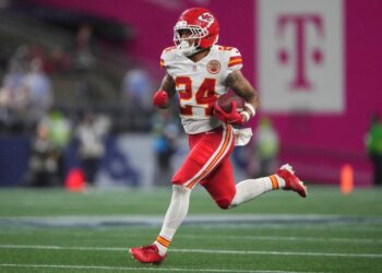 Kansas City Chiefs player running with the football.