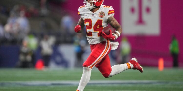 Kansas City Chiefs player running with the football.