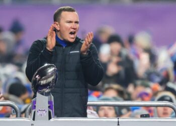 Boise State head coach celebrating with the Mountain West Championship trophy.