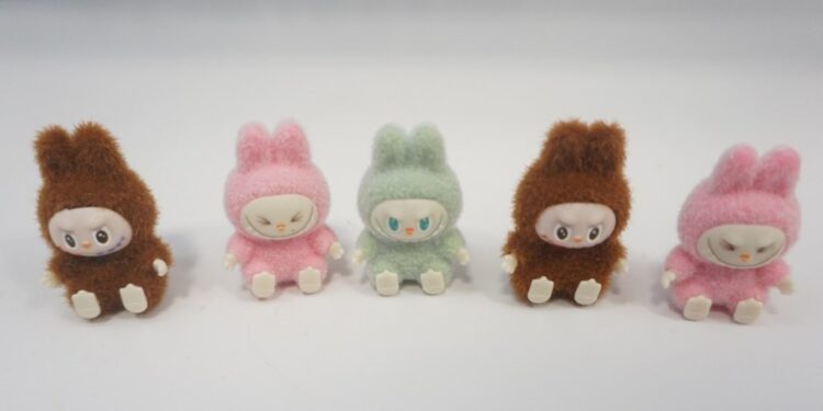 Five small plush rabbit toys in brown, pink, and green.