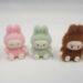 Five small plush rabbit toys in brown, pink, and green.