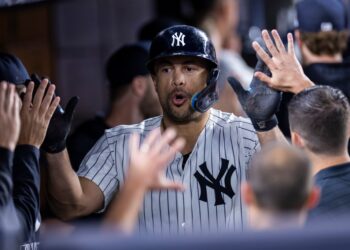 Giancarlo Stanton of the New York Yankees high-fiving teammates.