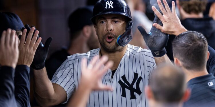 Giancarlo Stanton of the New York Yankees high-fiving teammates.