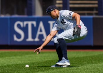 Giancarlo Stanton of the New York Yankees reaching for a baseball.