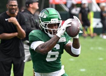 Jets wide receiver Malachi Corley catching a football at practice.
