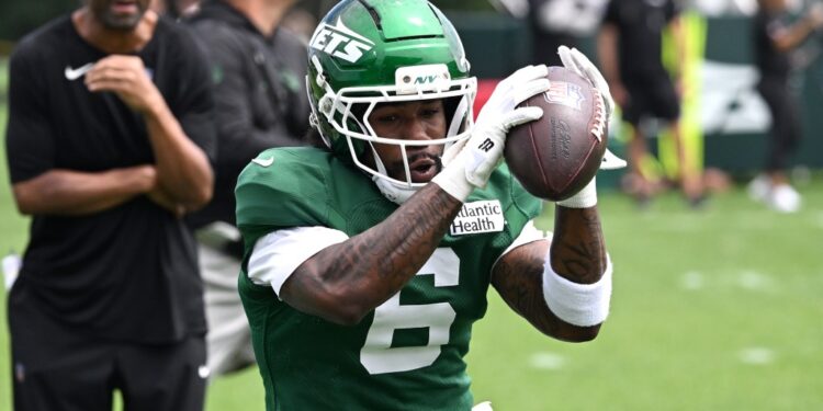 Jets wide receiver Malachi Corley catching a football at practice.