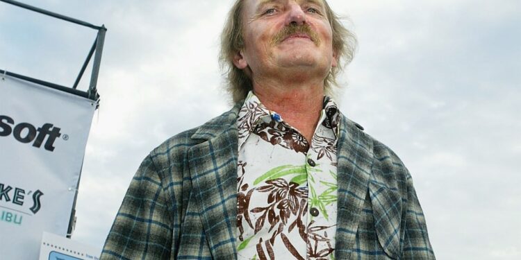 A man with blond hair and a mustache looking upward.