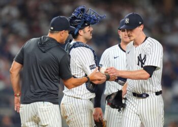 Yankees baseball players and coach conferring.