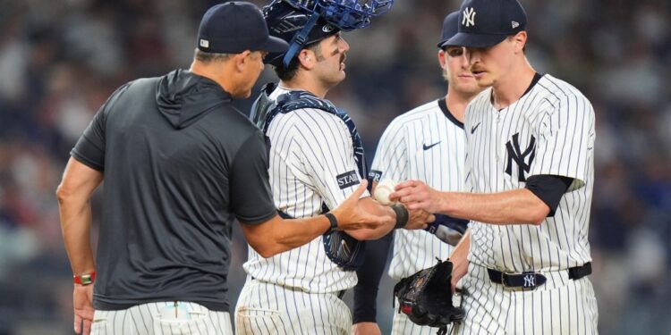 Yankees baseball players and coach conferring.
